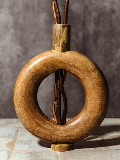 Beautifully handcrafted circular wooden vase with a smooth finish, designed to hold decorative branches or flowers. This unique, ethically made piece offers a minimalist yet striking look, perfect for sustainable home decor.