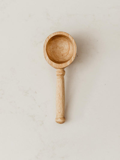 Coffee Scoop on white counter with slight detail seen on handle.