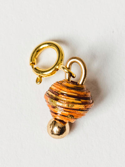 Burnt orange bead charm on gold clasp. 