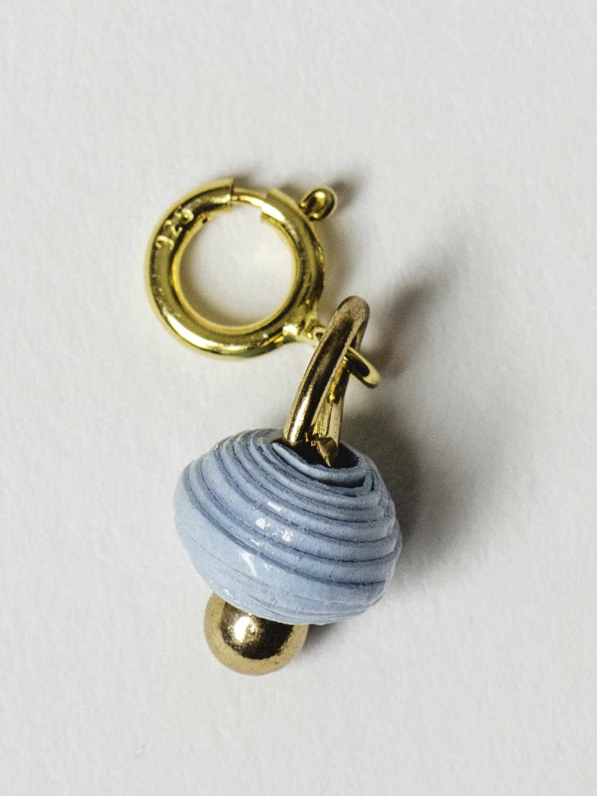 cloudy blue bead charm on gold clasp. 