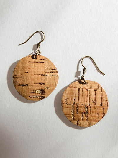 Circular cork textured earrings on a white surface.