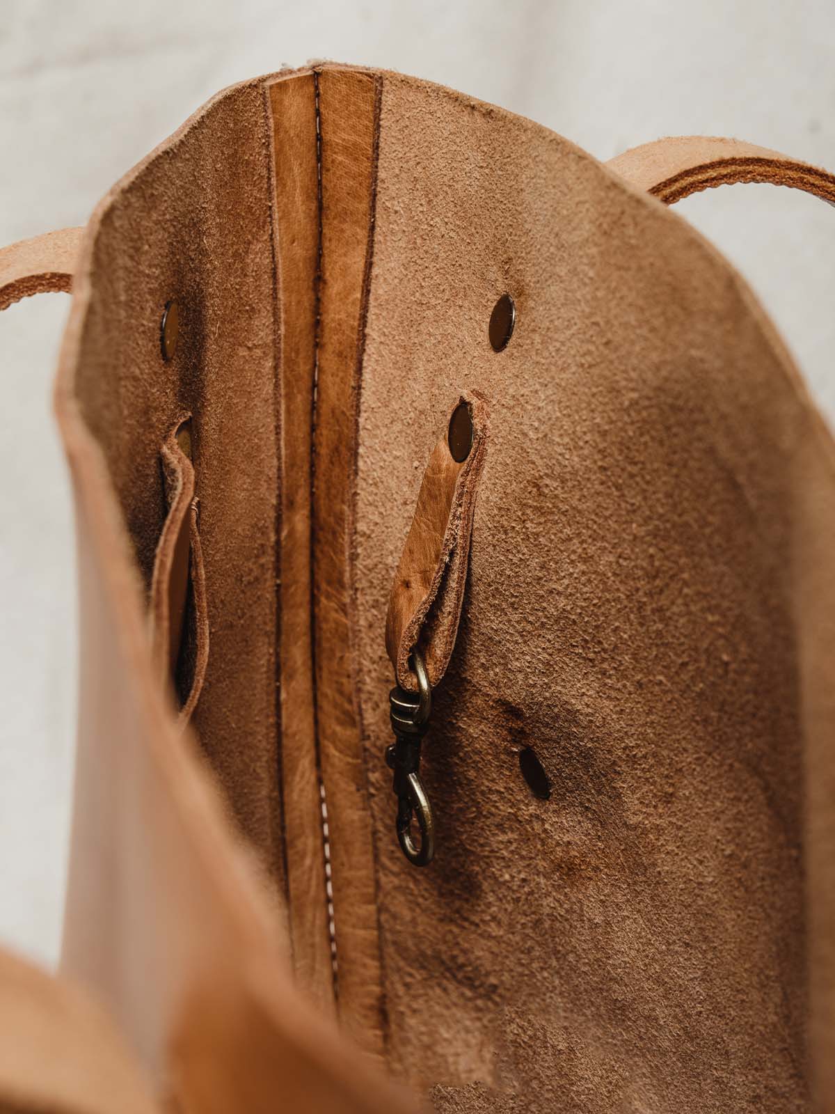 Interior of hazelnut colored leather handbag with large interior pocket and clasp for wallets etc. 