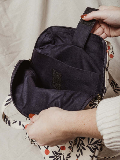 Model opening bag to show inside of the bag. Two pockets - one for a laptop and the other for addition storage.