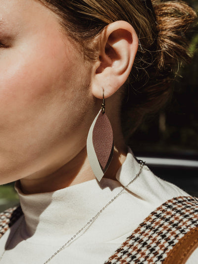 Female model wearing leather leaf shaped earrings.