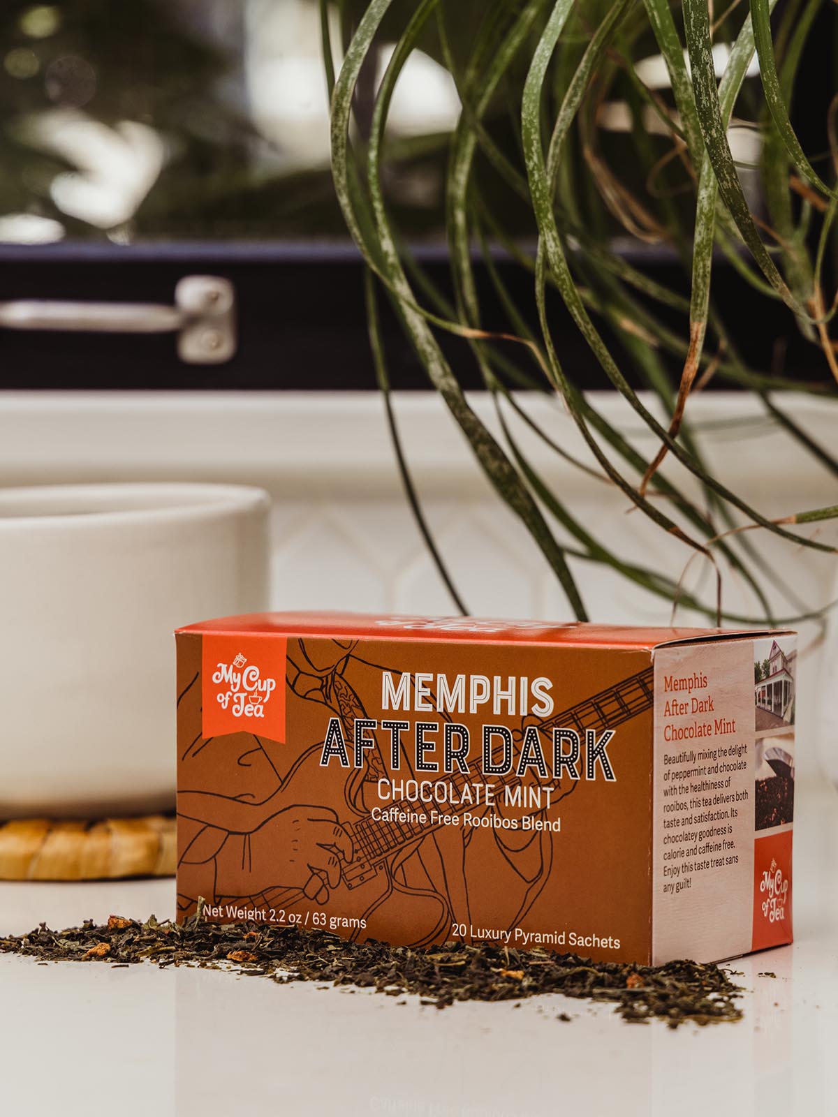 Chocolate Mint Tea box on counter with coffee cup and greenery.