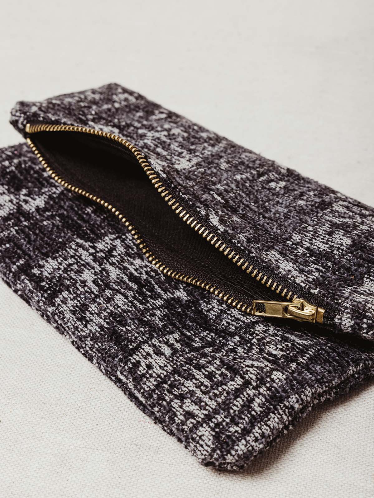 Open zipper of grey clutch