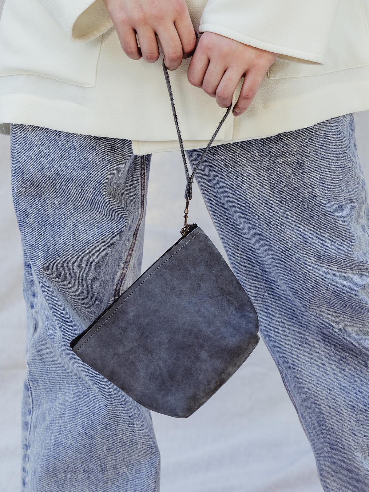 Female model holding blue sling wristlet 