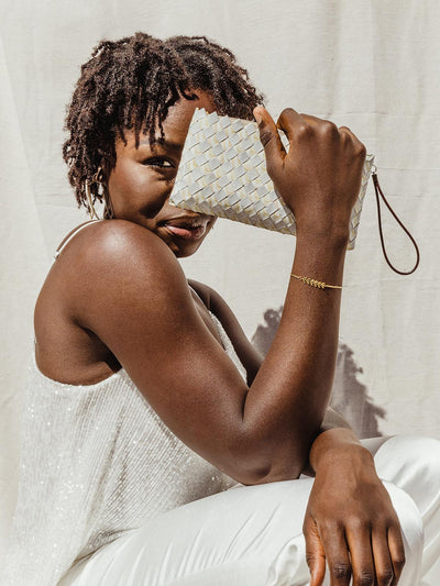 Female model holding white up-cycled cloth with white outfit.