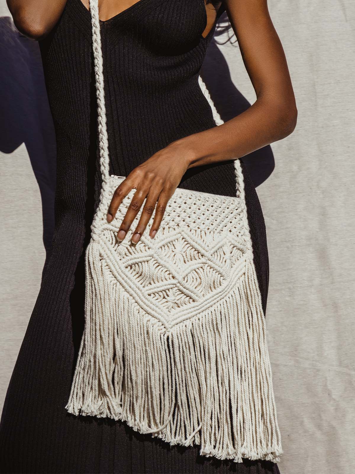 Female model wearing macramé purse in black dress crossbody.