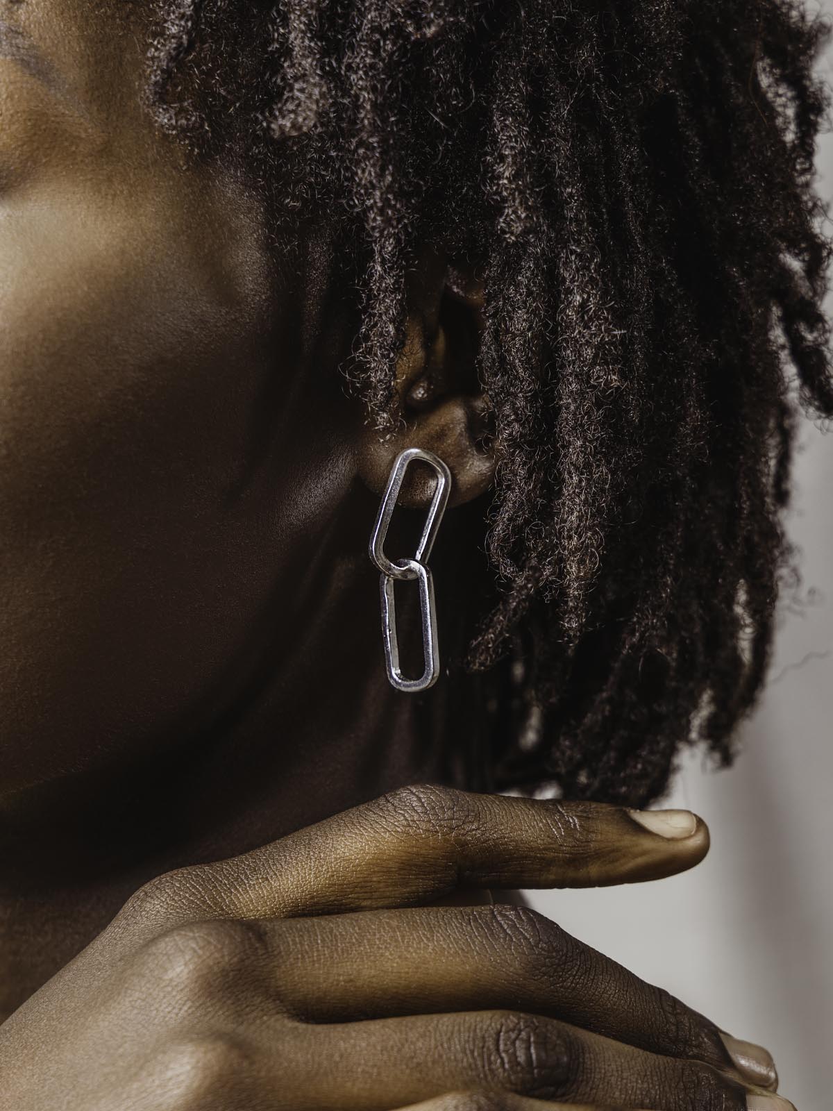 Close up of model's ear with silver earrings on