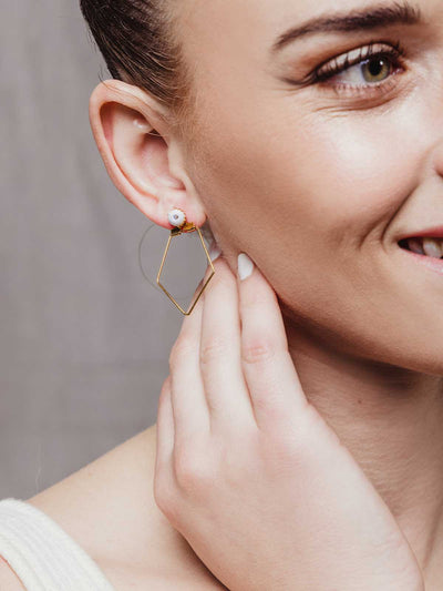 Women smiling with close up of Geometric gold earring