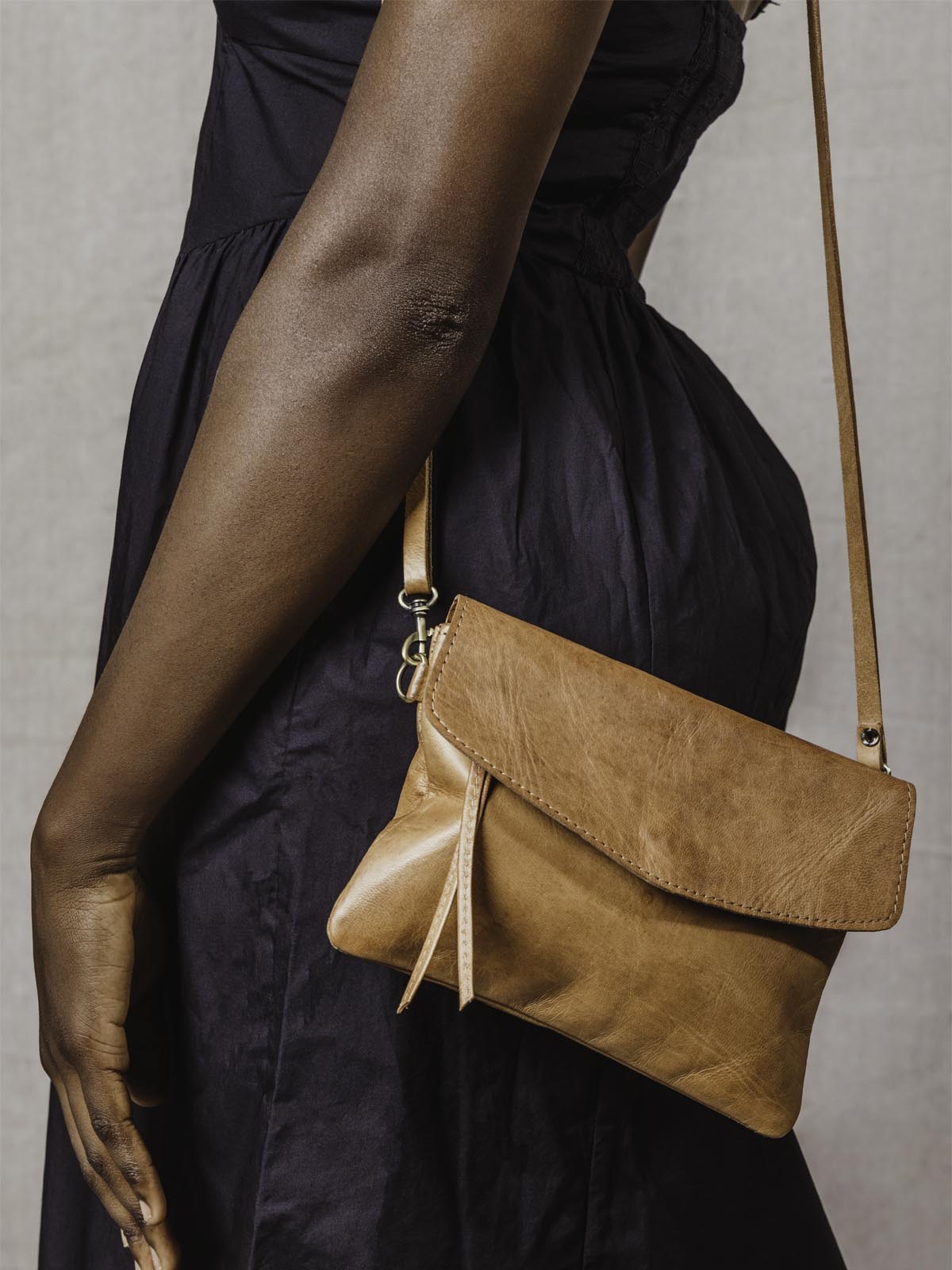 Model wearing the brown leather crossbody clutch