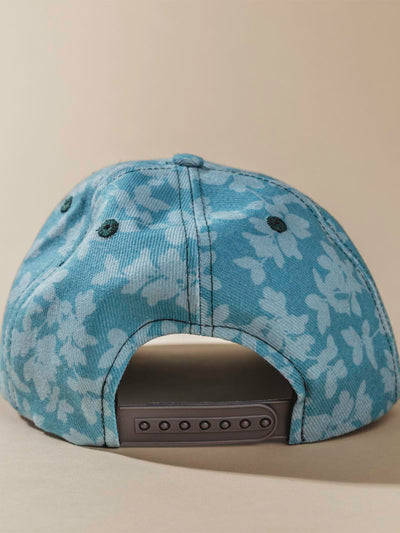 Back of teal Hat with light floral design on tan background.