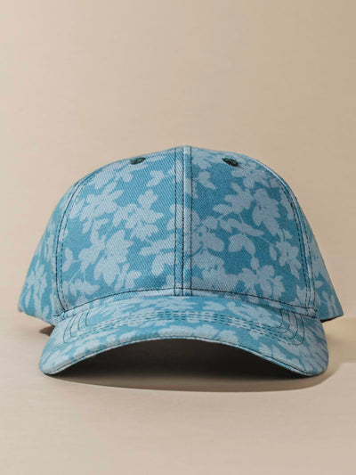 Front of teal Hat with light floral design on tan background.