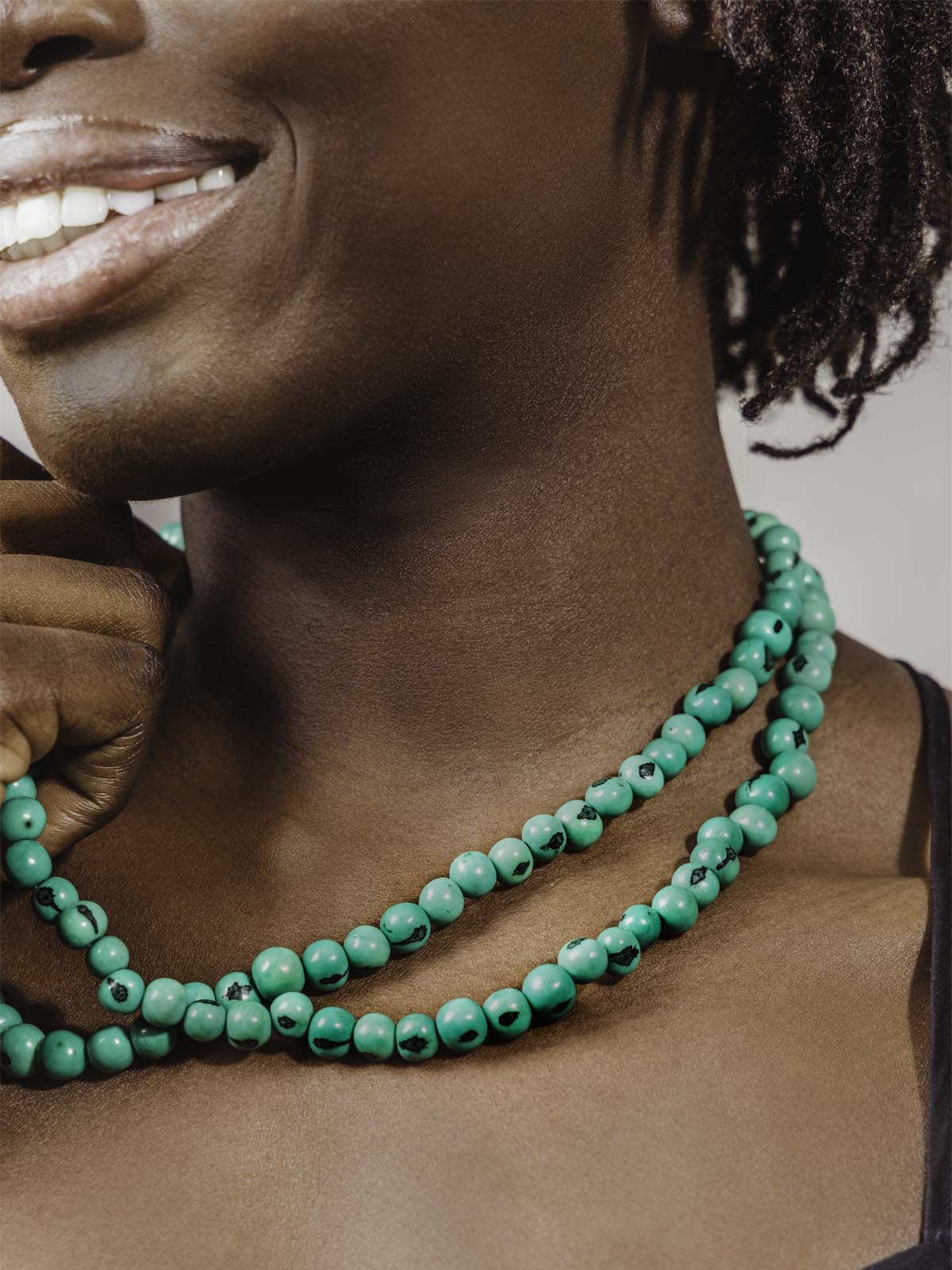 Close up of necklace beads worn on model.