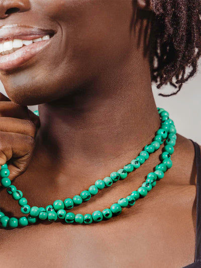 Close up of necklace beads worn on model.